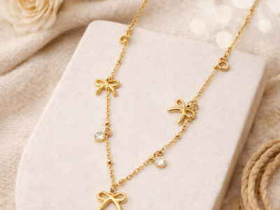 Gold multi bow charm necklace with crystal accents styled for elegant gifting