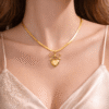 Gold bow heart pendant necklace with snake chain worn on neck with elegant feminine styling